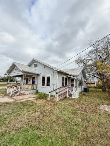 a front view of house with yard and trees around