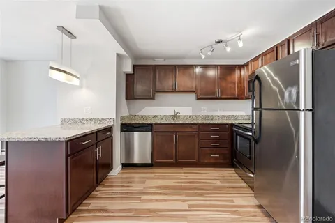 a kitchen with stainless steel appliances granite countertop a refrigerator and a stove top oven
