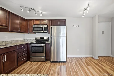 a kitchen with granite countertop stainless steel appliances and wooden cabinets