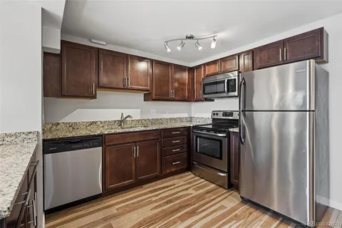 a kitchen with granite countertop stainless steel appliances and wooden cabinets