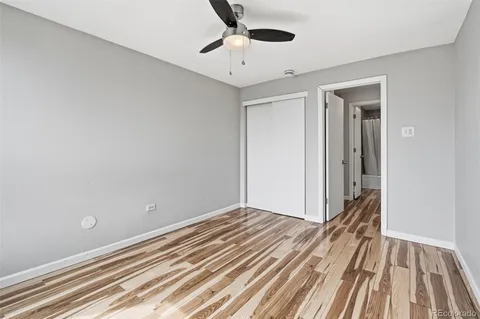 a view of a room with wooden floor and a ceiling fan