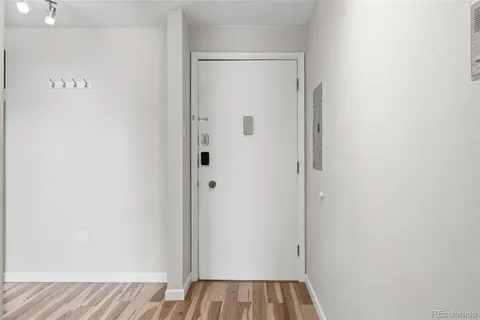 a view of a hallway with wooden floor and closet