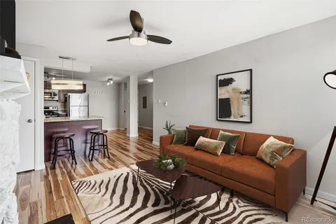 a living room with furniture a ceiling fan and a rug