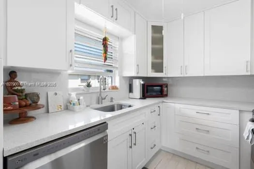 a kitchen with cabinets appliances a sink a faucet and a window