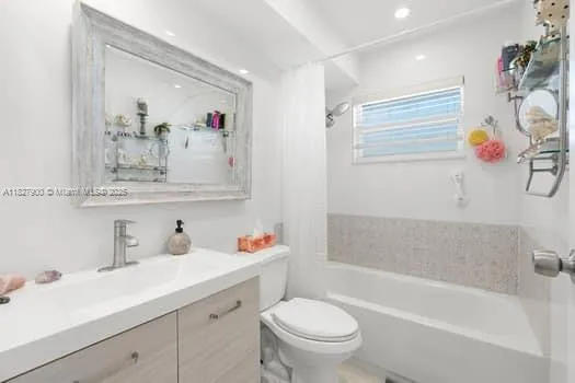 a bathroom with a sink mirror vanity and toilet