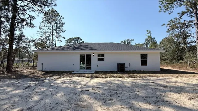 a view of a house with a large tree and a yard