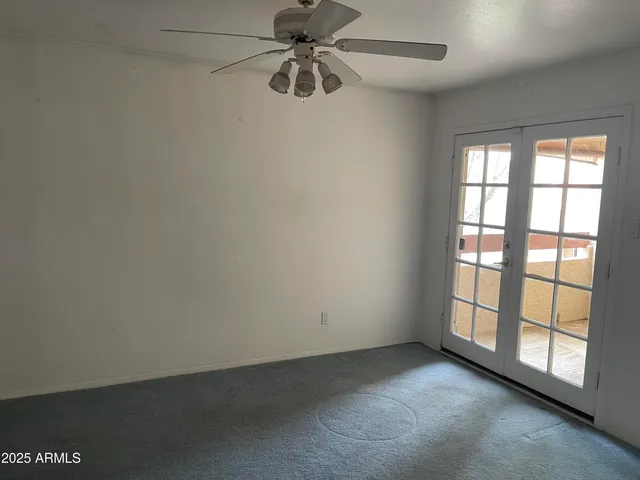 an empty room with chandelier fan