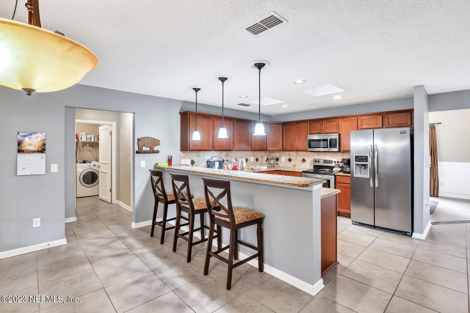 3001 Nautilus Road Middleburg, FL 32068 - Photo 12 of 26 a kitchen with stainless steel appliances a table chairs refrigerator and cabinets