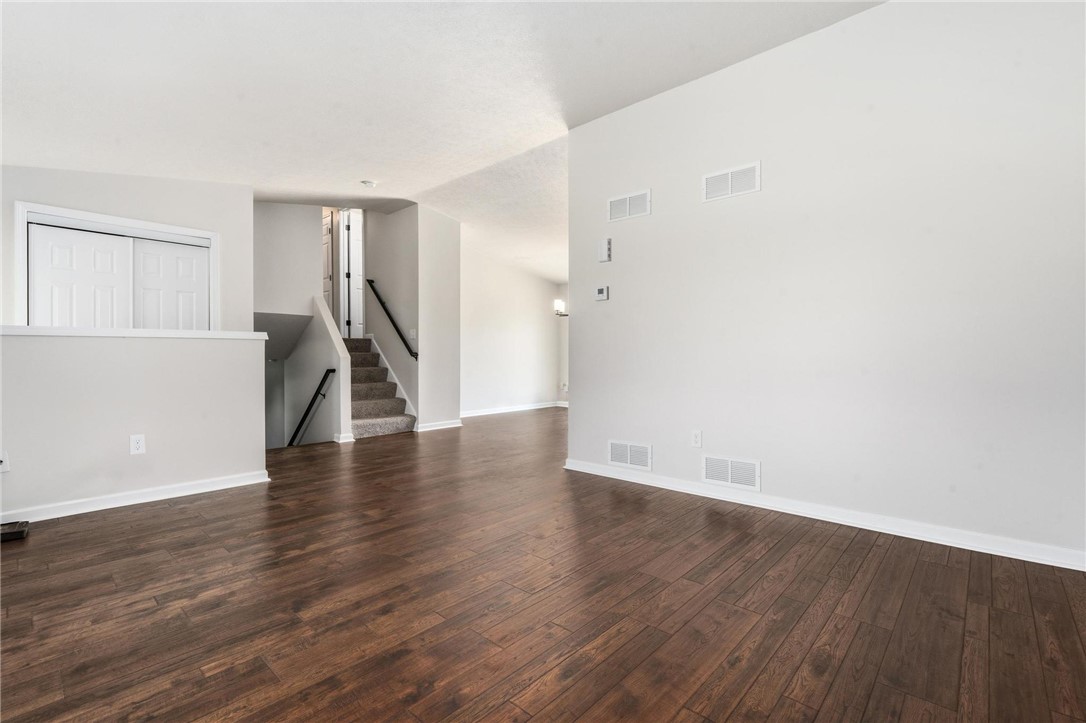1353 Foust Road Xenia, OH 45385 - Photo 30 of 50 This bright living space features rich hardwood floors and an inviting staircase, creating a warm ambiance.