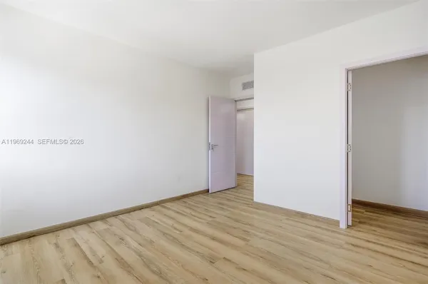 a view of an empty room with wooden floor