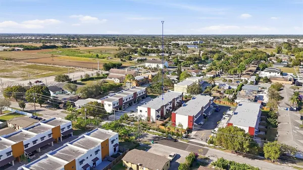 an aerial view of a city with lots of residential buildings ocean and mountain view in back
