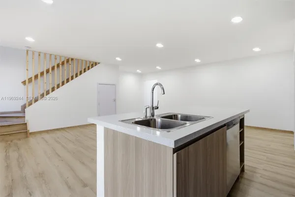 a kitchen with sink and mirror