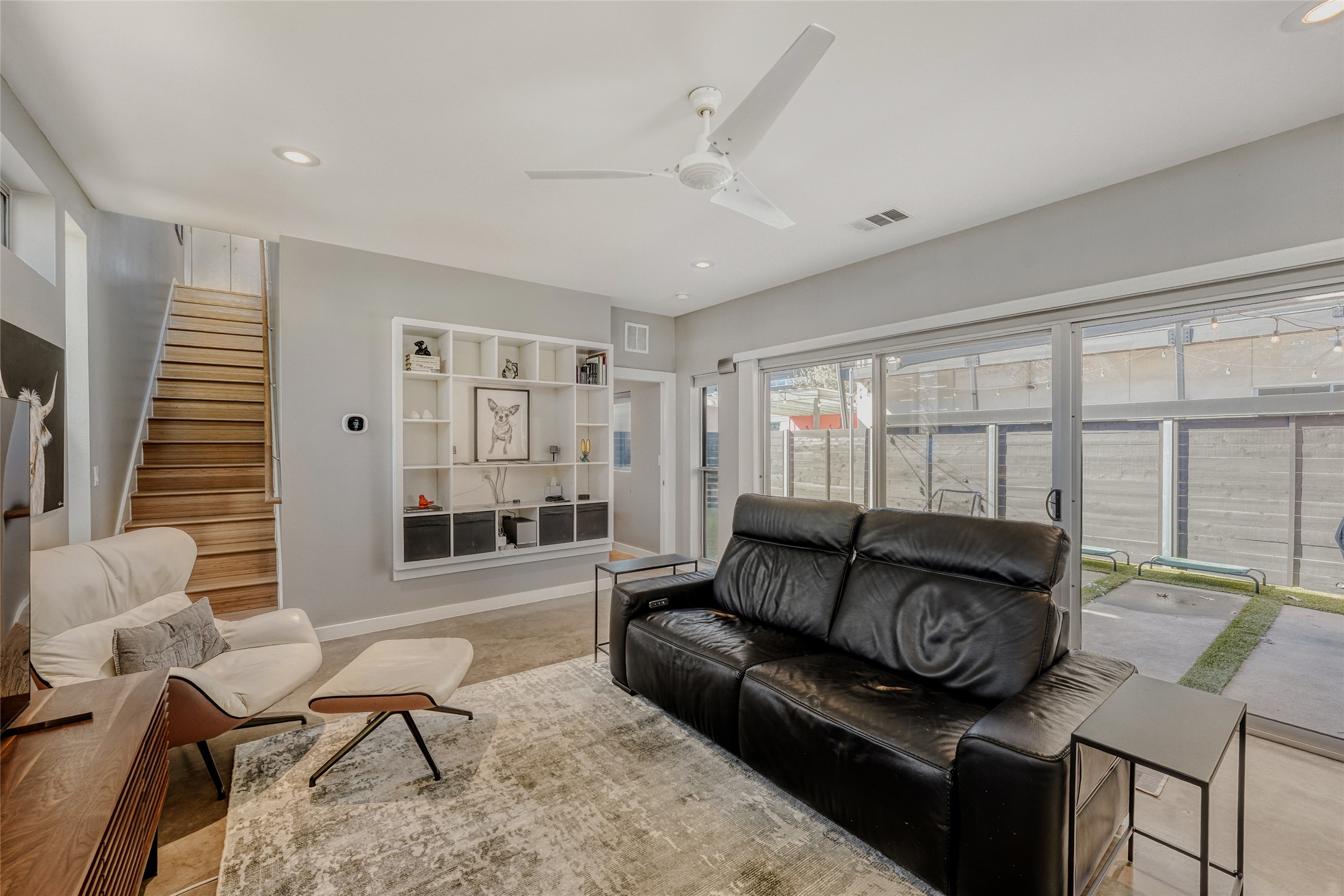 5909 Lux Street Austin, TX 78721 - Photo 2 of 28 Living area with recessed lighting, built-in bookcase, ceiling fan and sliding door w/automatic shades