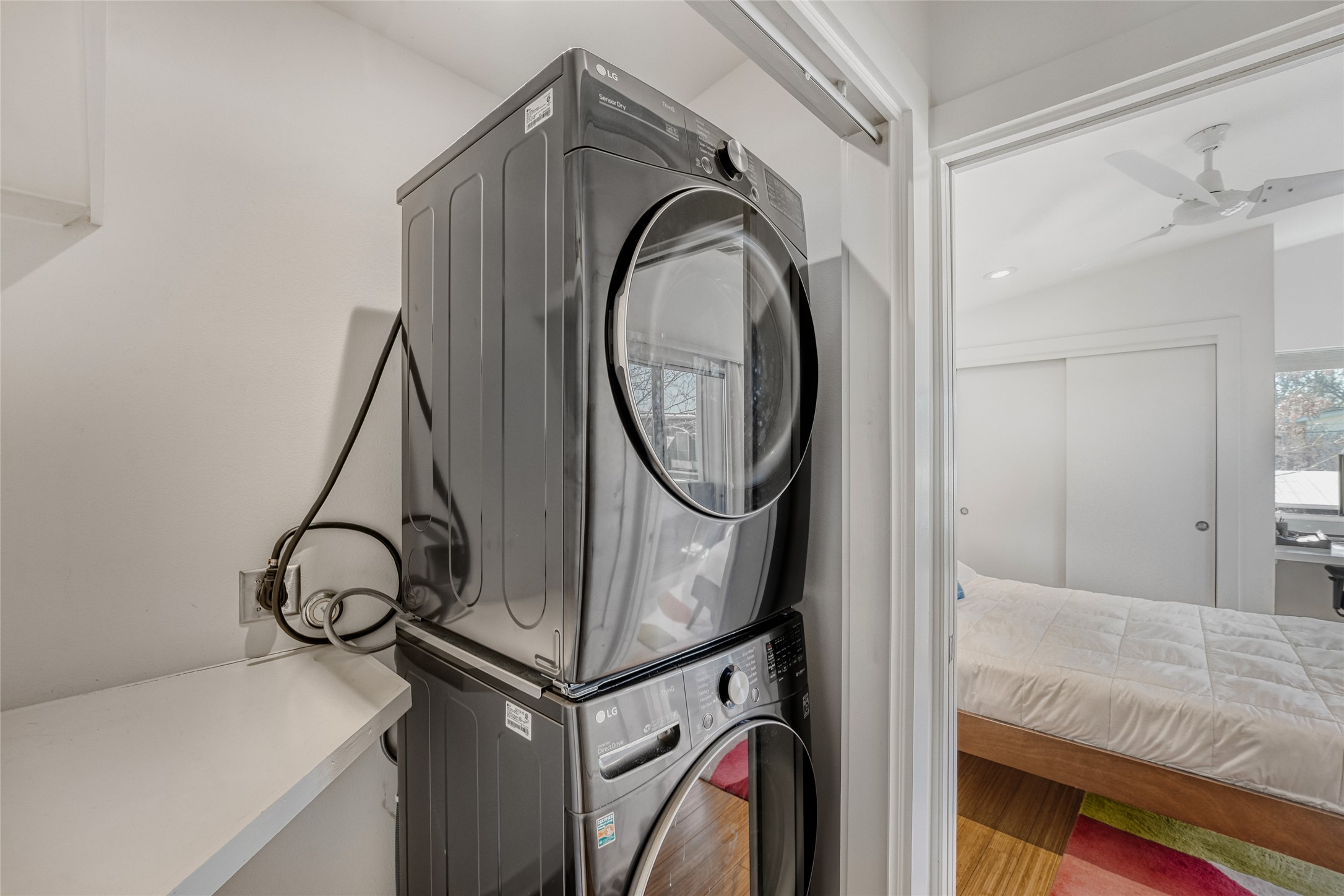 5909 Lux Street Austin, TX 78721 - Photo 25 of 28 Laundry room featuring stacked washer / dryer and clothes folding shelf