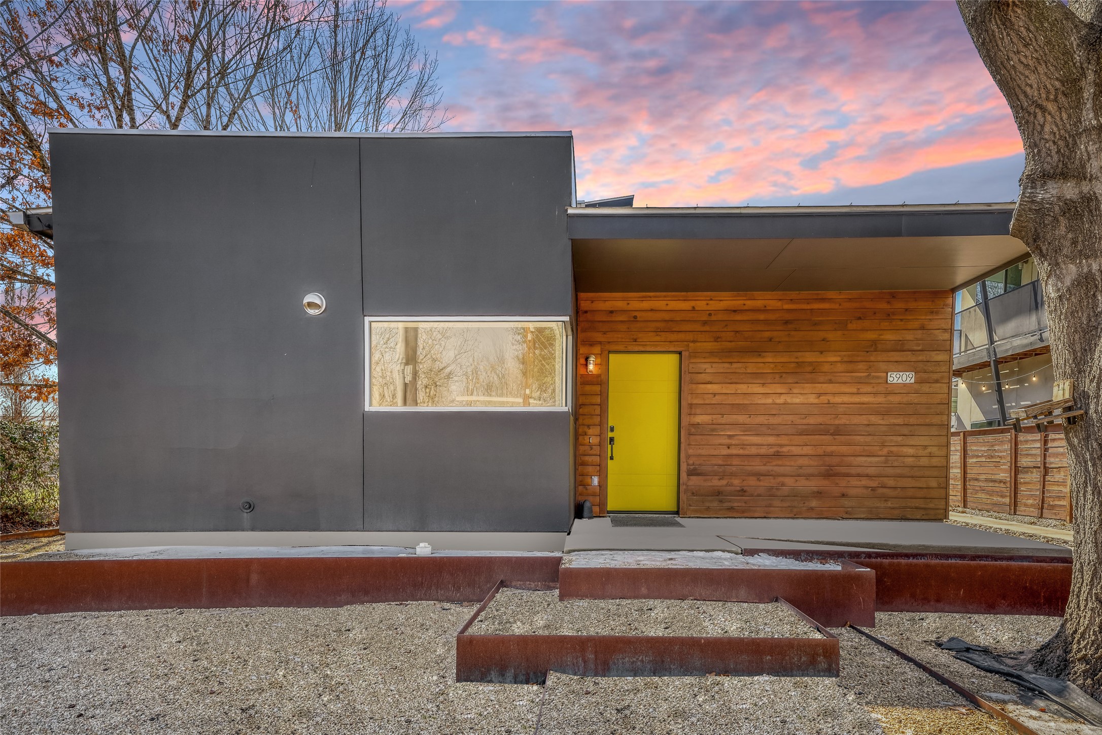 5909 Lux Street Austin, TX 78721 - Photo 27 of 28 Entrance to property with concrete ramp, stucco, large windows & attractive cedar