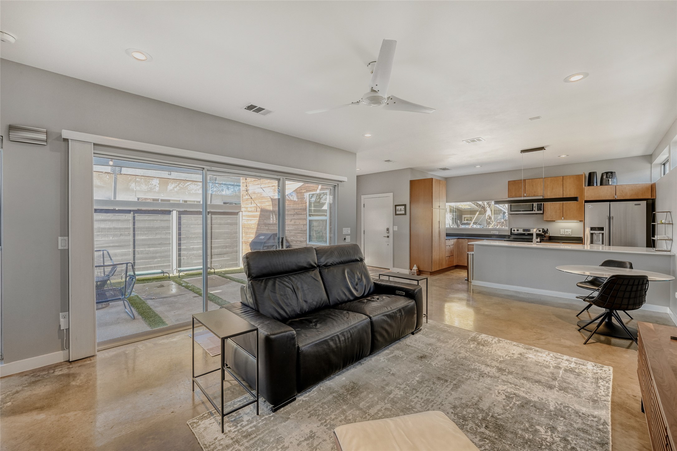 5909 Lux Street Austin, TX 78721 - Photo 3 of 28 Living room with concrete flooring, a ceiling fan, and recessed lighting