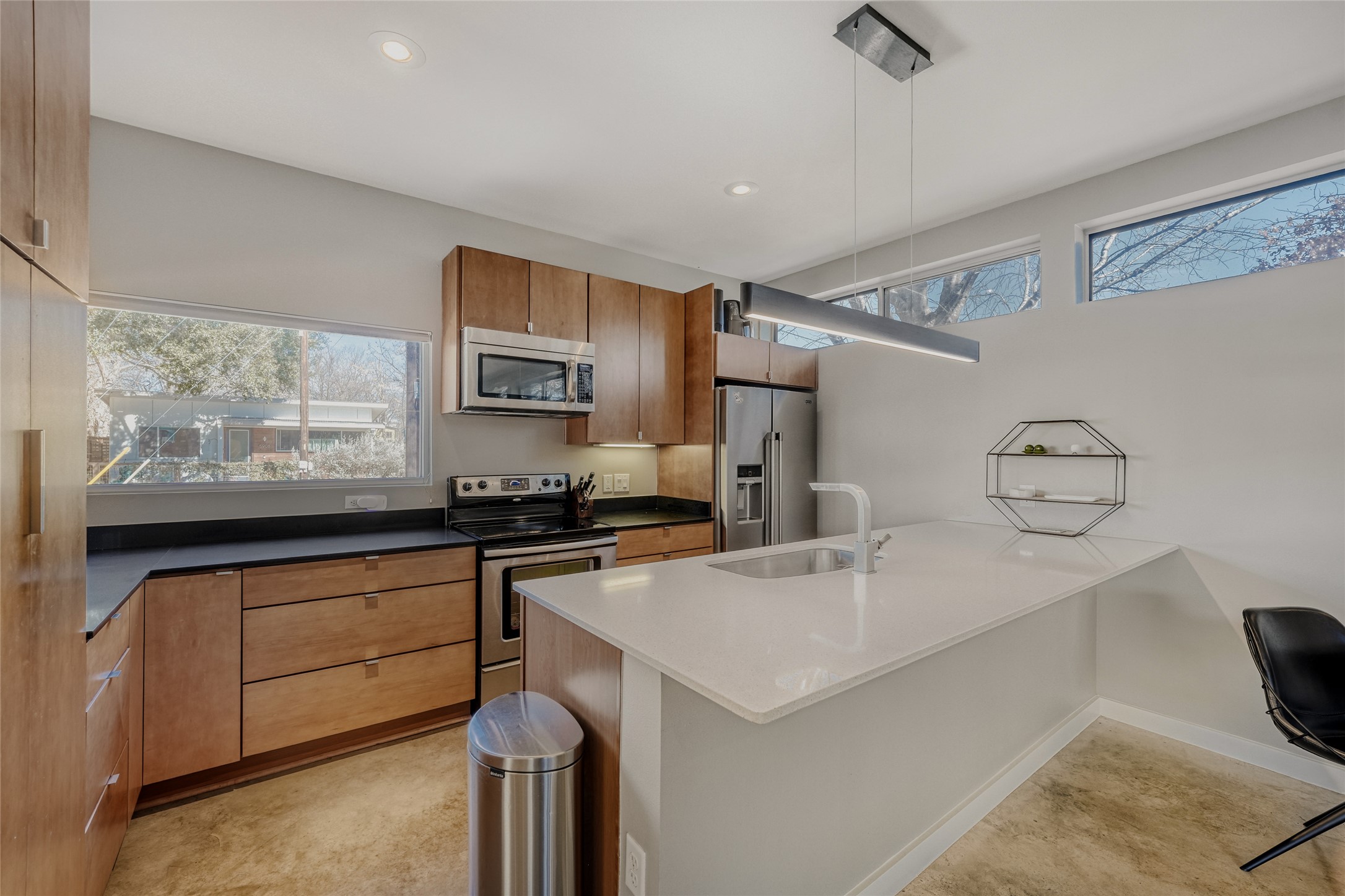 5909 Lux Street Austin, TX 78721 - Photo 4 of 28 Kitchen with appliances with stainless steel finishes, wood cabinets, decorative light fixtures, plenty of natural light, and recessed lighting