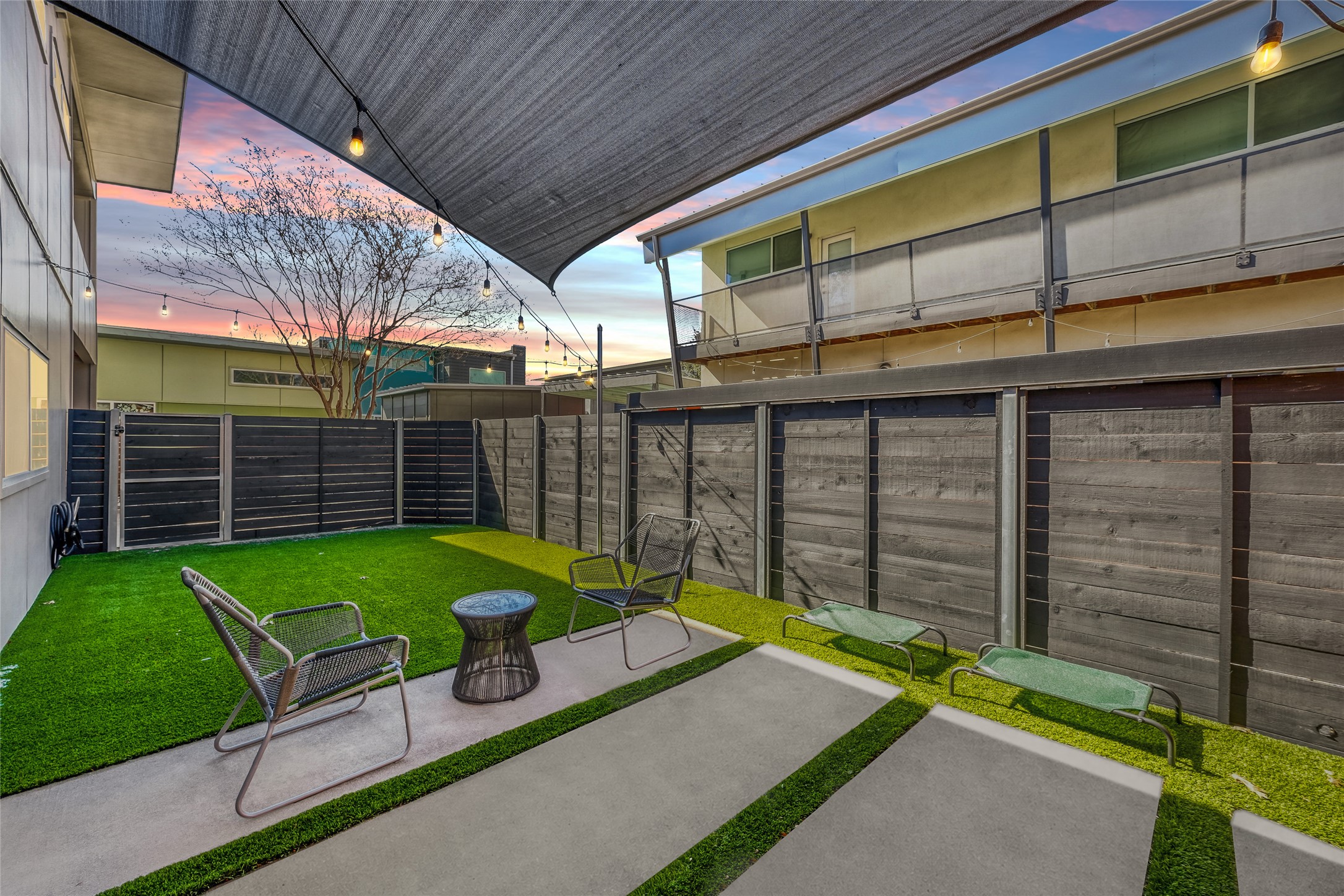 5909 Lux Street Austin, TX 78721 - Photo 5 of 28 Fenced backyard featuring a patio and professionally installed turf