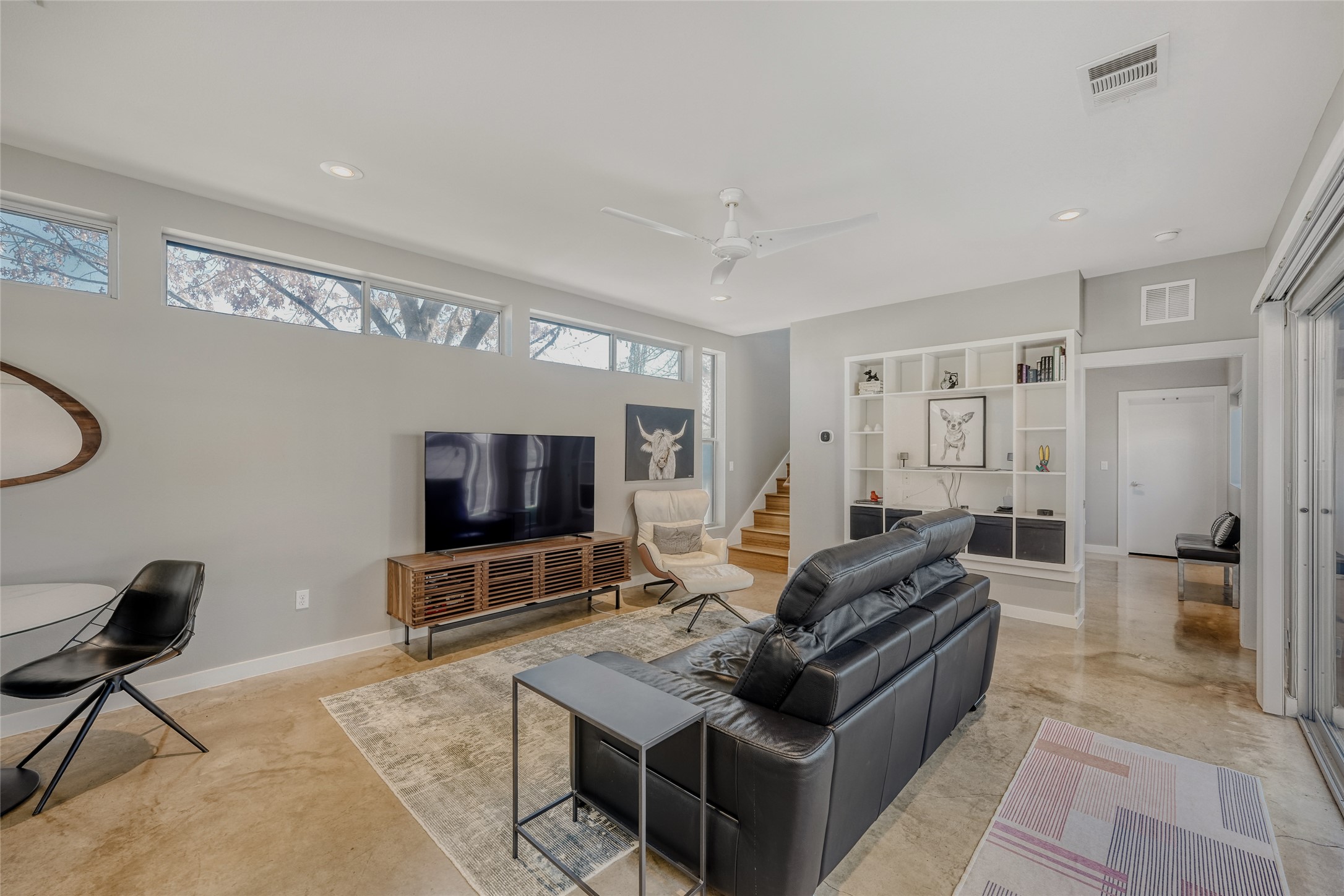 5909 Lux Street Austin, TX 78721 - Photo 8 of 28 Living area featuring recessed lighting, built in bookcase, a ceiling fan, and stairs leading upstairs