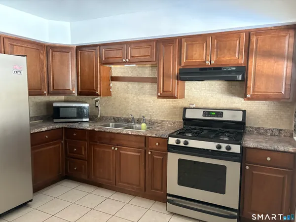 a kitchen with granite countertop wooden cabinets and a stove top oven
