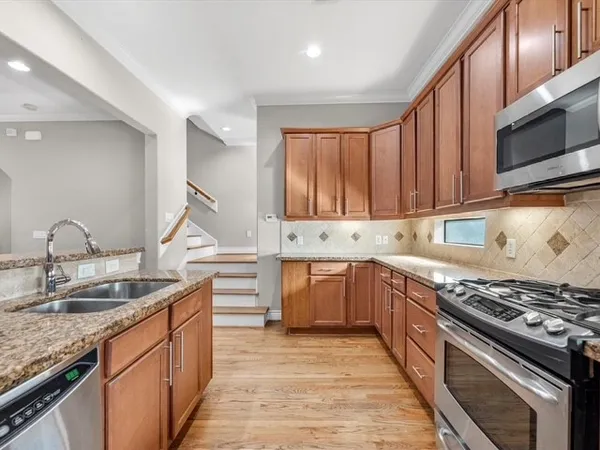 a kitchen with granite countertop stainless steel appliances and wooden cabinets