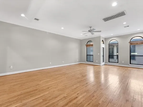 an empty room with wooden floor chandelier and glass door