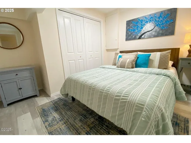 a bedroom with a bed and a painting on the wall