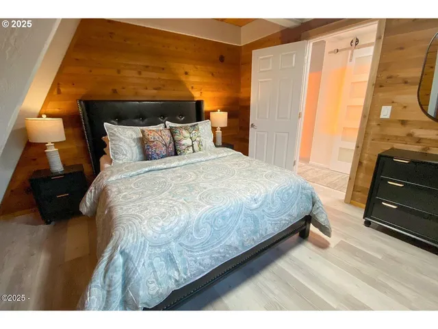 a bedroom with a bed and wooden floor