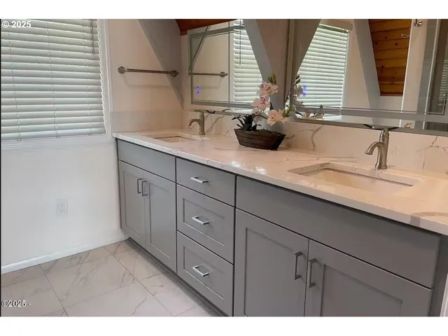 a bathroom with a double vanity sink and window