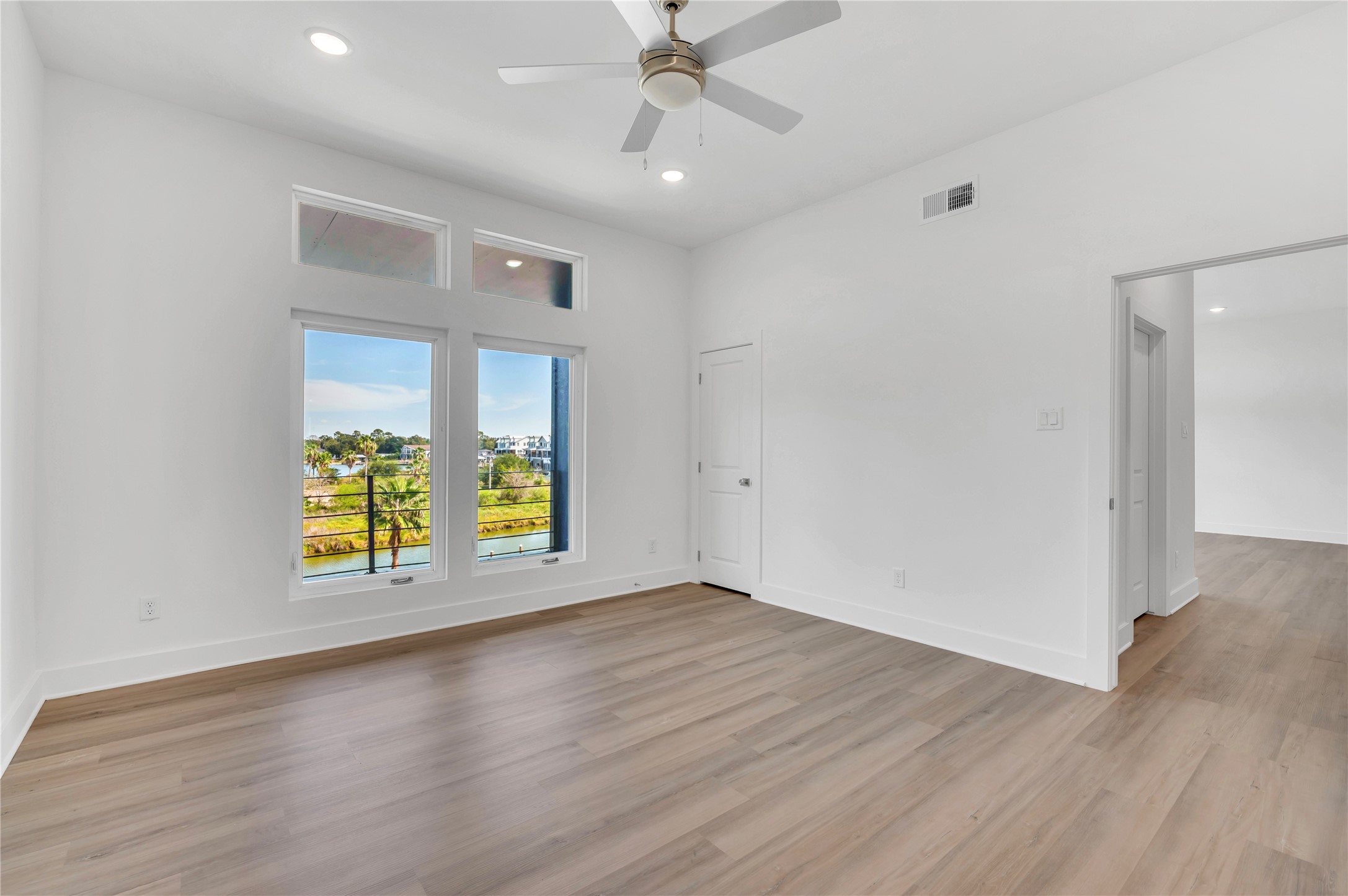 119 Kirby Road, Unit 5205 Seabrook, TX 77586 - Photo 40 of 46 Bright and spacious room featuring large windows with scenic views, sleek hardwood flooring, and a modern ceiling fan.
