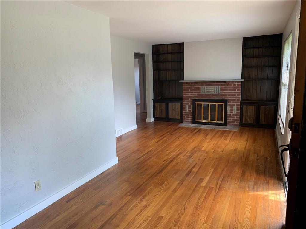 4227 Greenridge Road Pittsburgh, PA 15234 - Photo 3 of 23 Living room with gas fireplace and built-in bookshelves. Polished hardwood floors throughout.