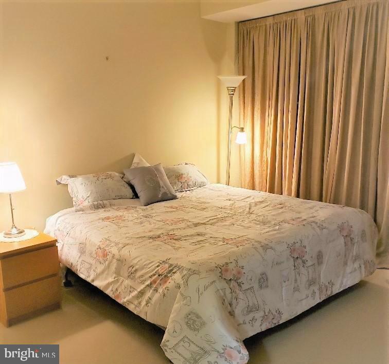 1530 Key Boulevard, Unit 1319 Arlington, VA 22209 - Photo 19 of 30 a large bed sitting in a bedroom next to a window