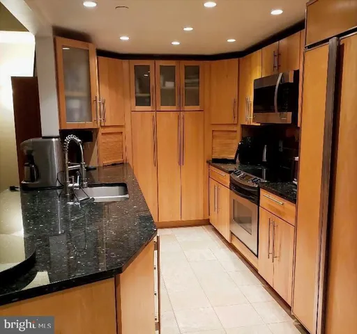 a kitchen with stainless steel appliances granite countertop a sink refrigerator and microwave