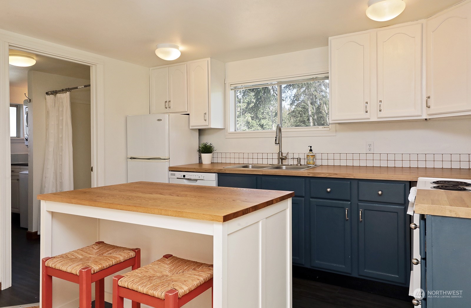 5612 Osprey Road Freeland, WA 98249 - Photo 11 of 29 a kitchen with stainless steel appliances granite countertop a sink stove and refrigerator