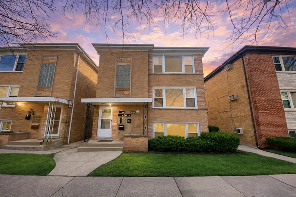 a front view of a house with a garden and yard