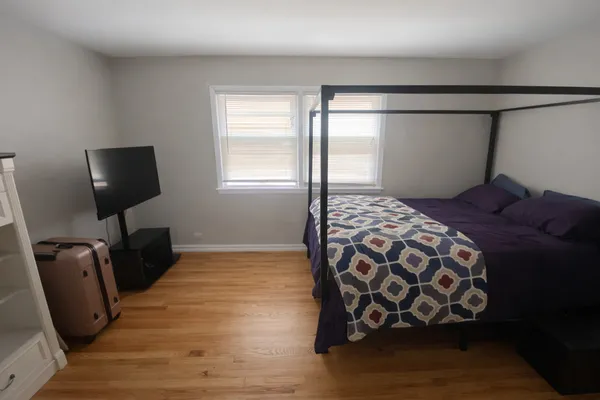 a bedroom with a bed and wooden floor