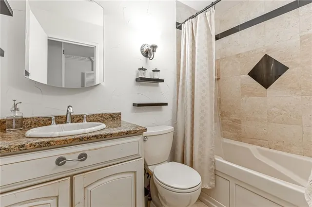 a spacious bedroom with a bed a dresser and a chandelier