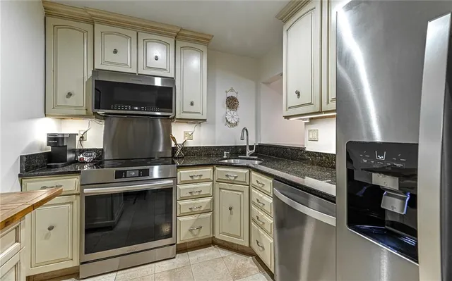 a kitchen with stainless steel appliances granite countertop a refrigerator and a sink