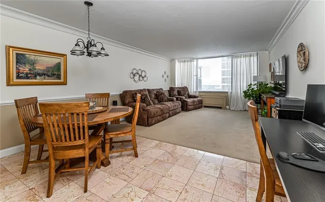 a living room with furniture and a dining table with window