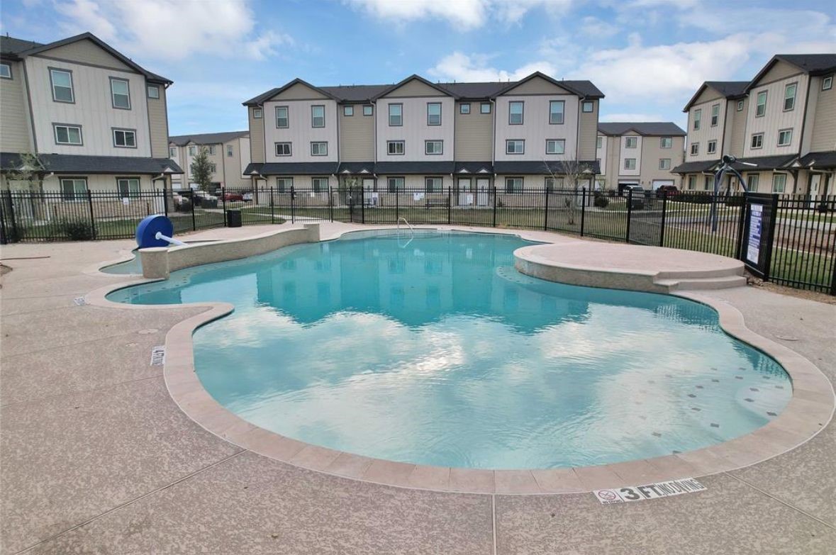 12603 Telge Road, Unit 23E Cypress, TX 77429 - Photo 23 of 25 a view of a swimming pool in front of a brick house