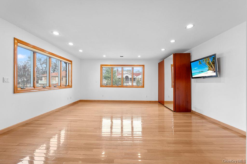 64-16 211th Street Queens, NY 11364 - Photo 15 of 22 a view of an empty room window and wooden floor