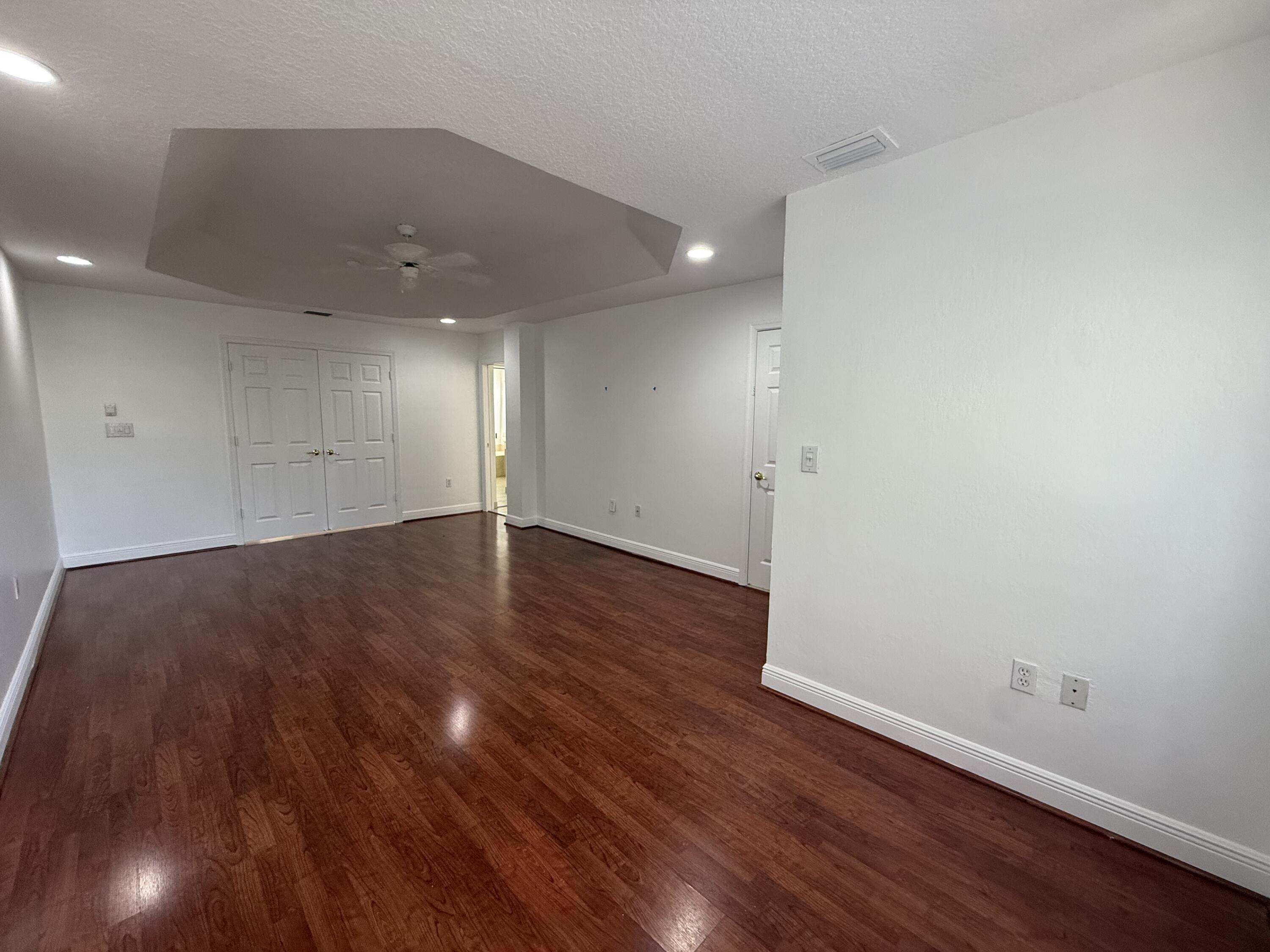 11553 Big Sky Court Boca Raton, FL 33498 - Photo 12 of 43 an empty room with wooden floor and windows
