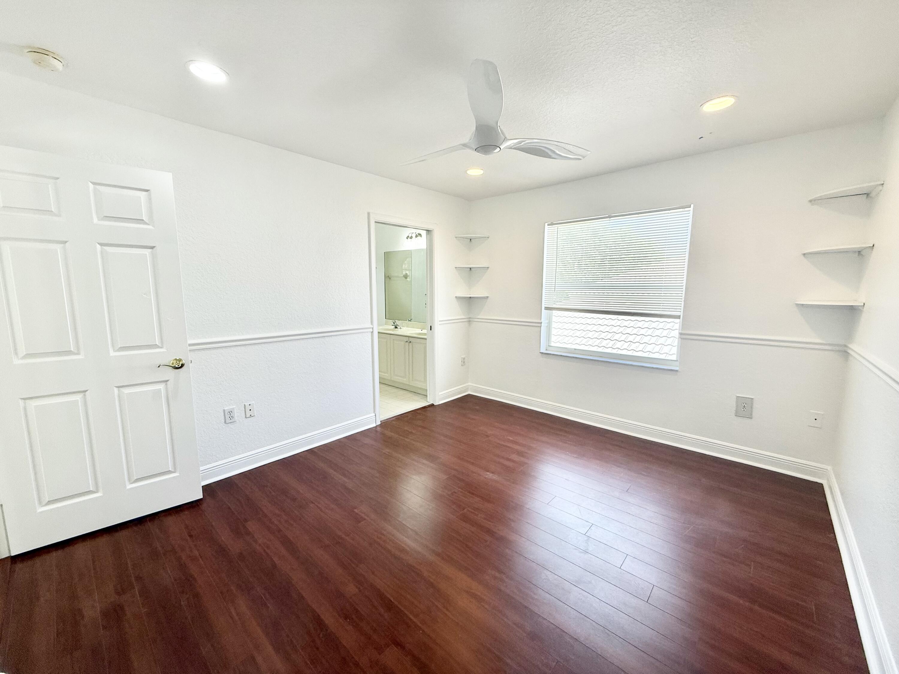 11553 Big Sky Court Boca Raton, FL 33498 - Photo 14 of 43 an empty room with wooden floor cabinet and windows