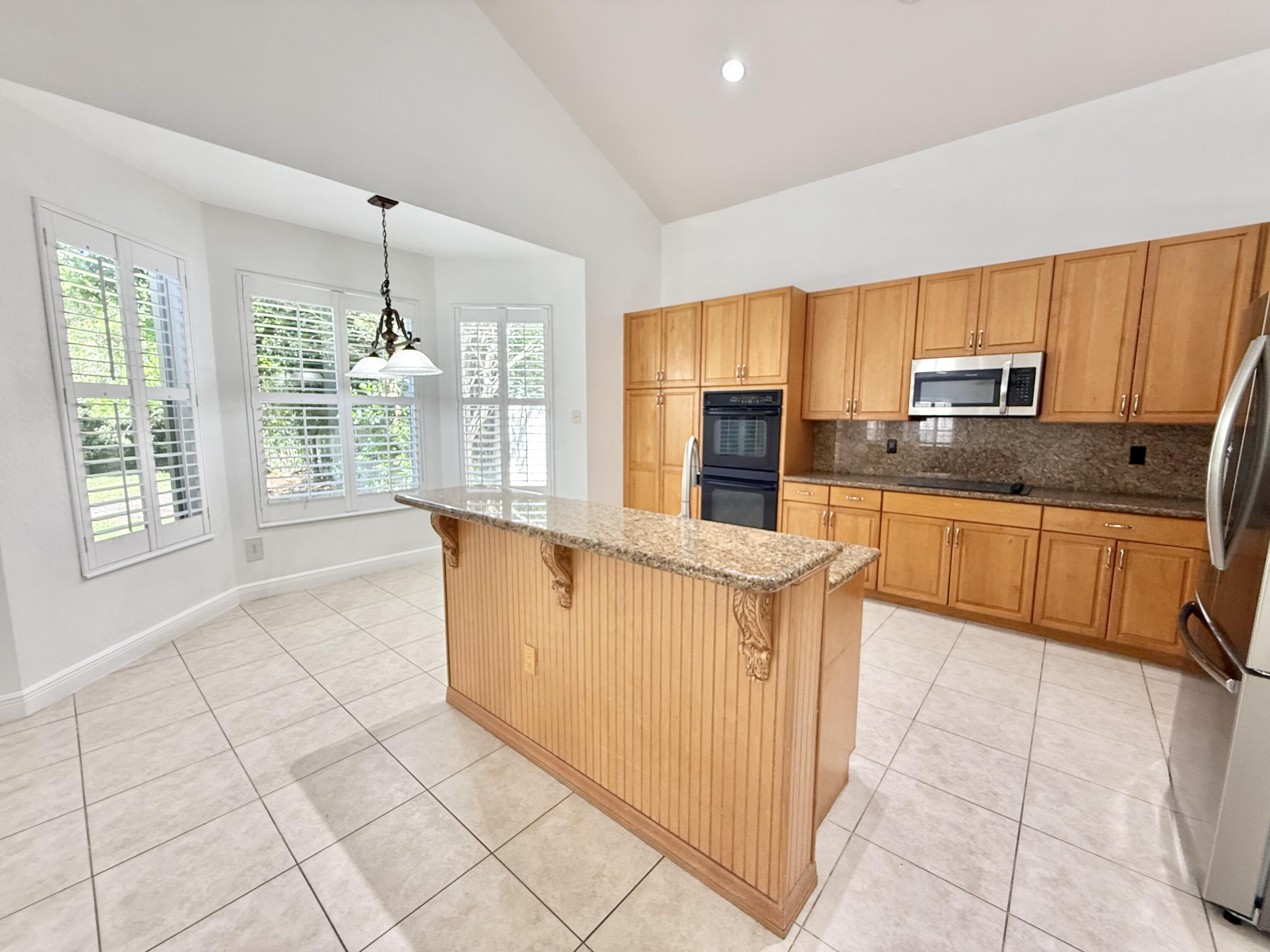 11553 Big Sky Court Boca Raton, FL 33498 - Photo 20 of 43 a kitchen with stainless steel appliances granite countertop a stove a sink and a refrigerator