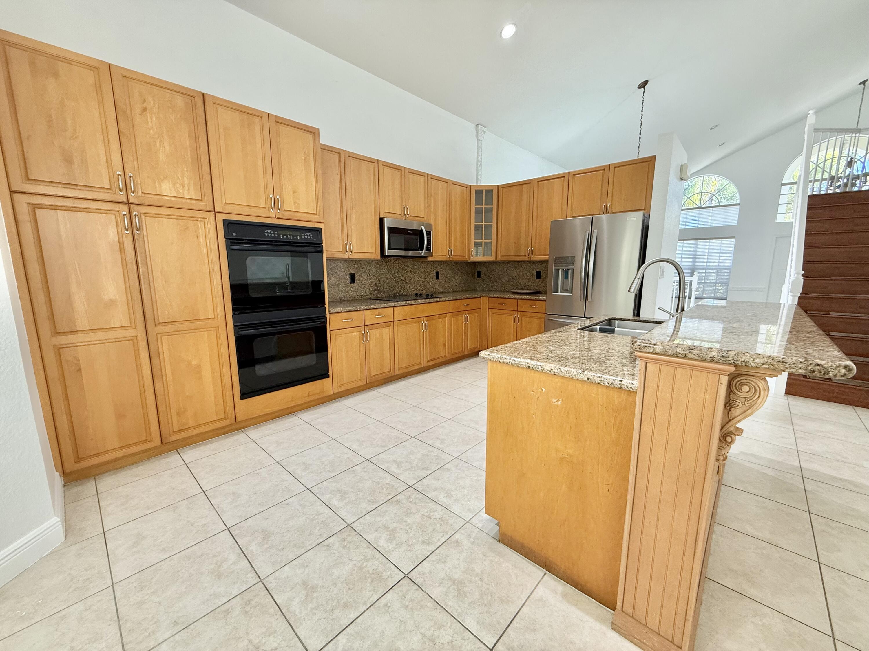 11553 Big Sky Court Boca Raton, FL 33498 - Photo 23 of 43 a kitchen with stainless steel appliances a refrigerator sink and cabinets