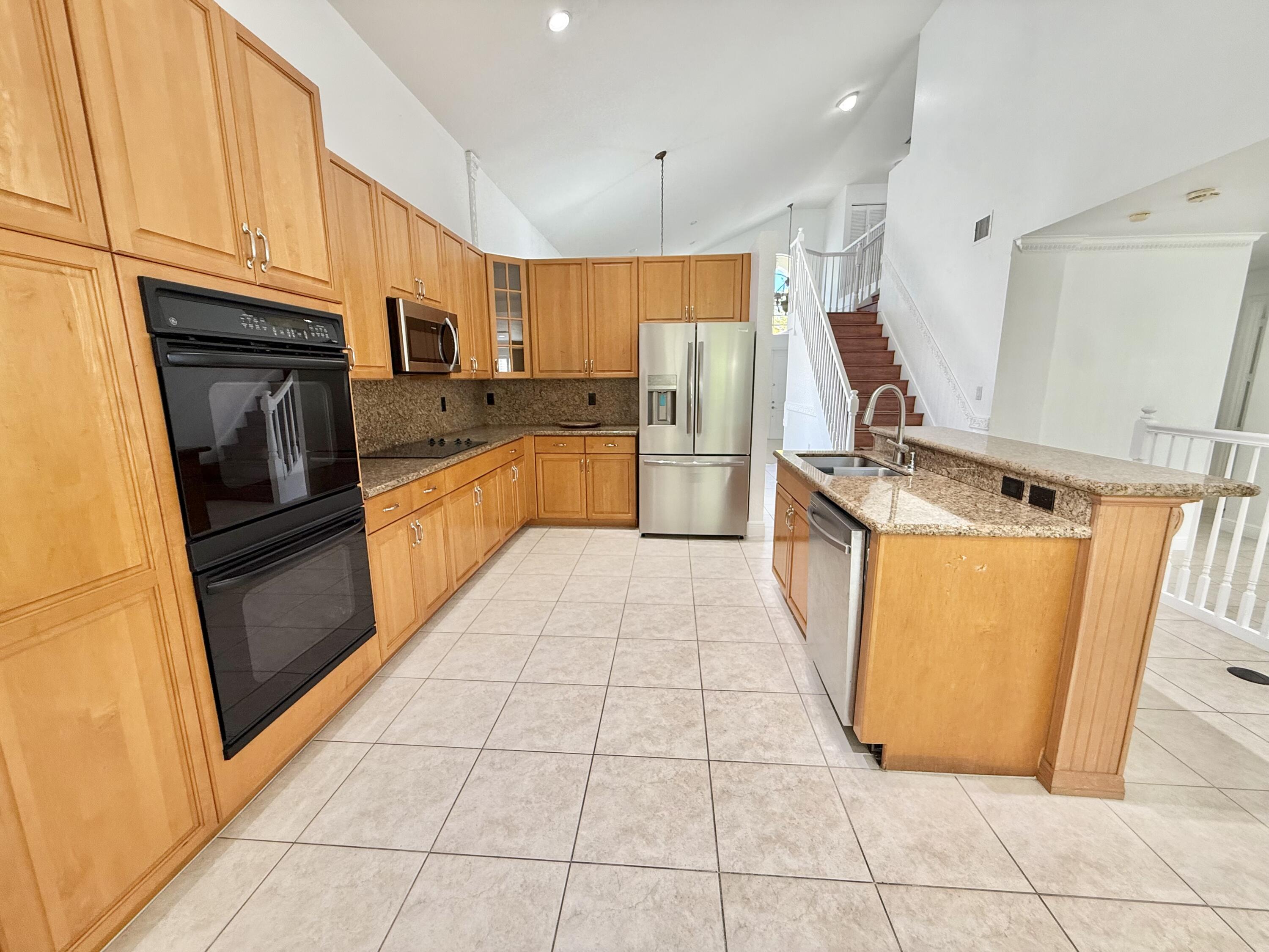 11553 Big Sky Court Boca Raton, FL 33498 - Photo 5 of 43 a kitchen with stainless steel appliances granite countertop a refrigerator a stove and a sink
