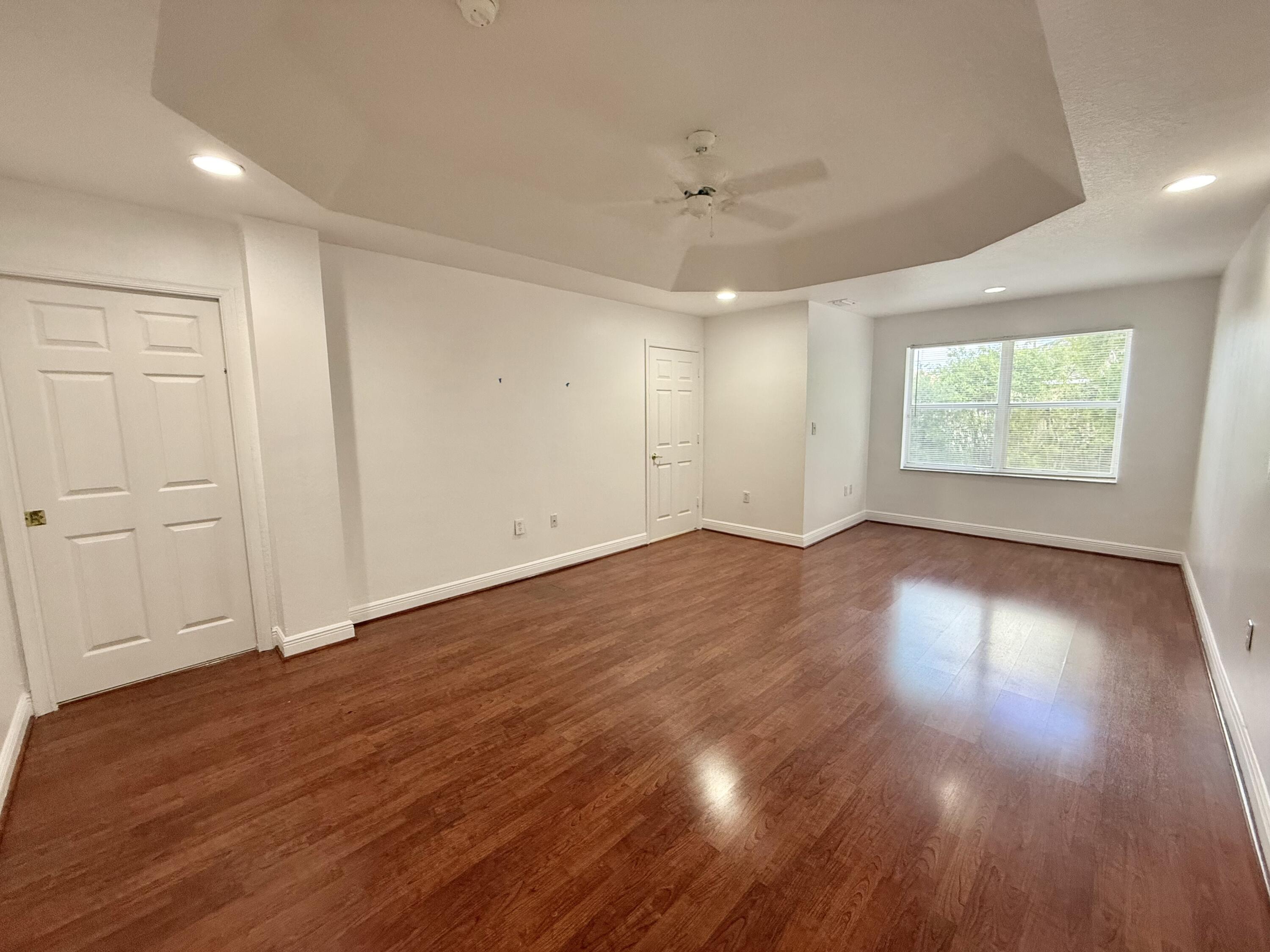 11553 Big Sky Court Boca Raton, FL 33498 - Photo 7 of 43 an empty room with wooden floor and windows