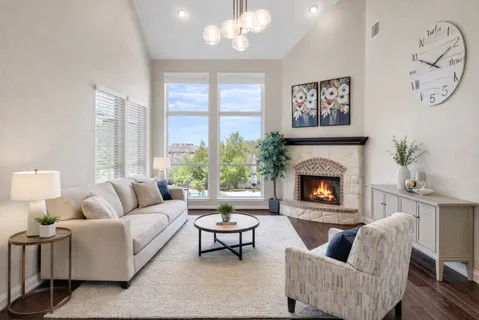 a living room with furniture fireplace and a large window