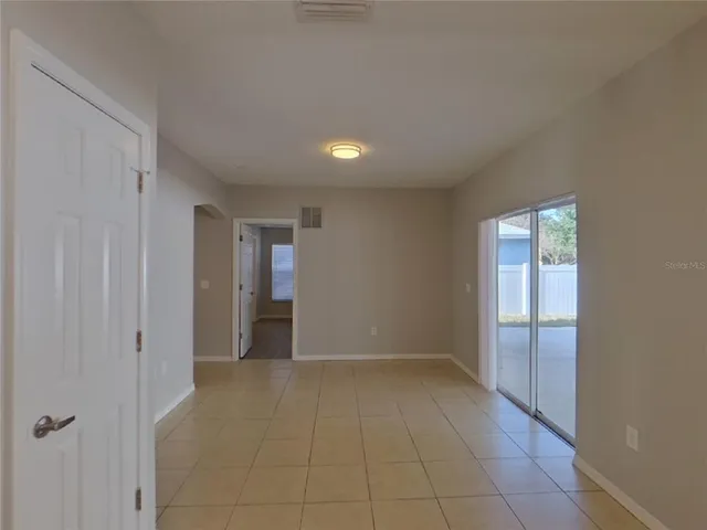 a view of an empty room with closet and a window