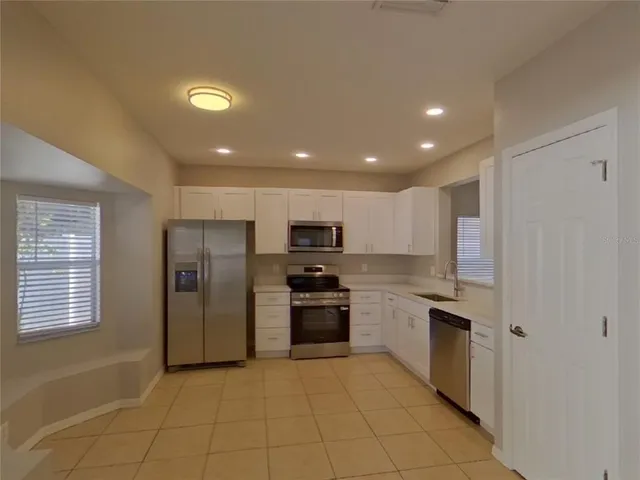 a kitchen with stainless steel appliances granite countertop a refrigerator and a stove top oven